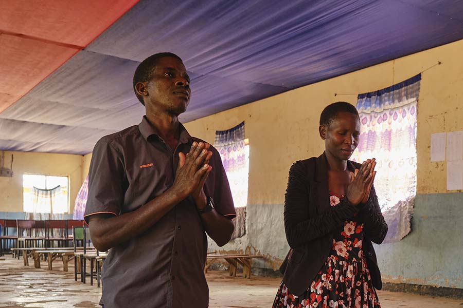 Ester Masangwa and her husband praying at the local AICT church.
